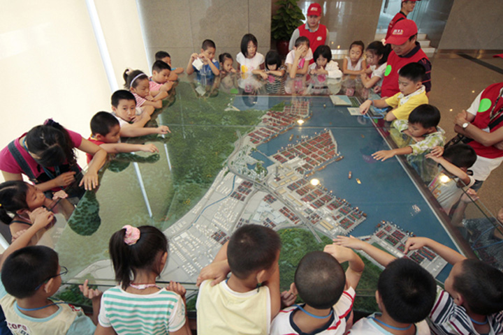 Members of YICT Volunteer Group explain for the children a scale model of Yantian Port 