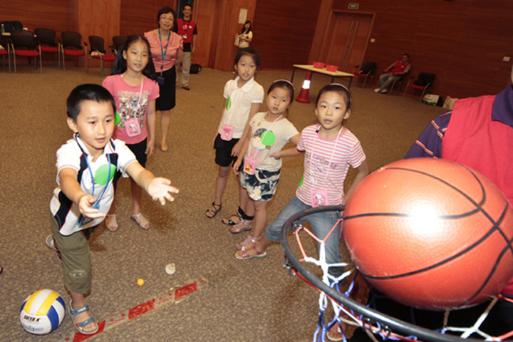 Children playing a slam dunk game gleefully 