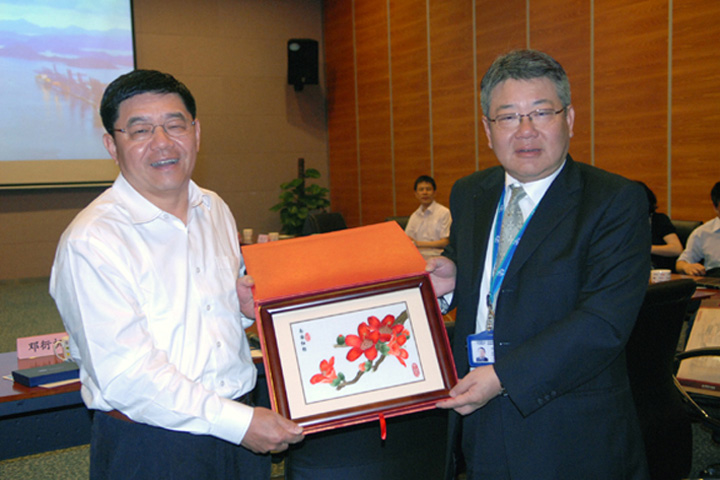 Chang Min (left), Director General of Guangzhou Port Authority, presents a piece of Guangdong embroidery craftwork as a souvenir to Edward Tang (right), YICT General Manager-Operation Services and Development.