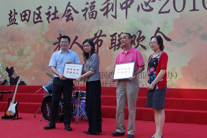 Yantian District Social Welfare Centre presents a tablet to YICT as a commendation for its elderly caring efforts.