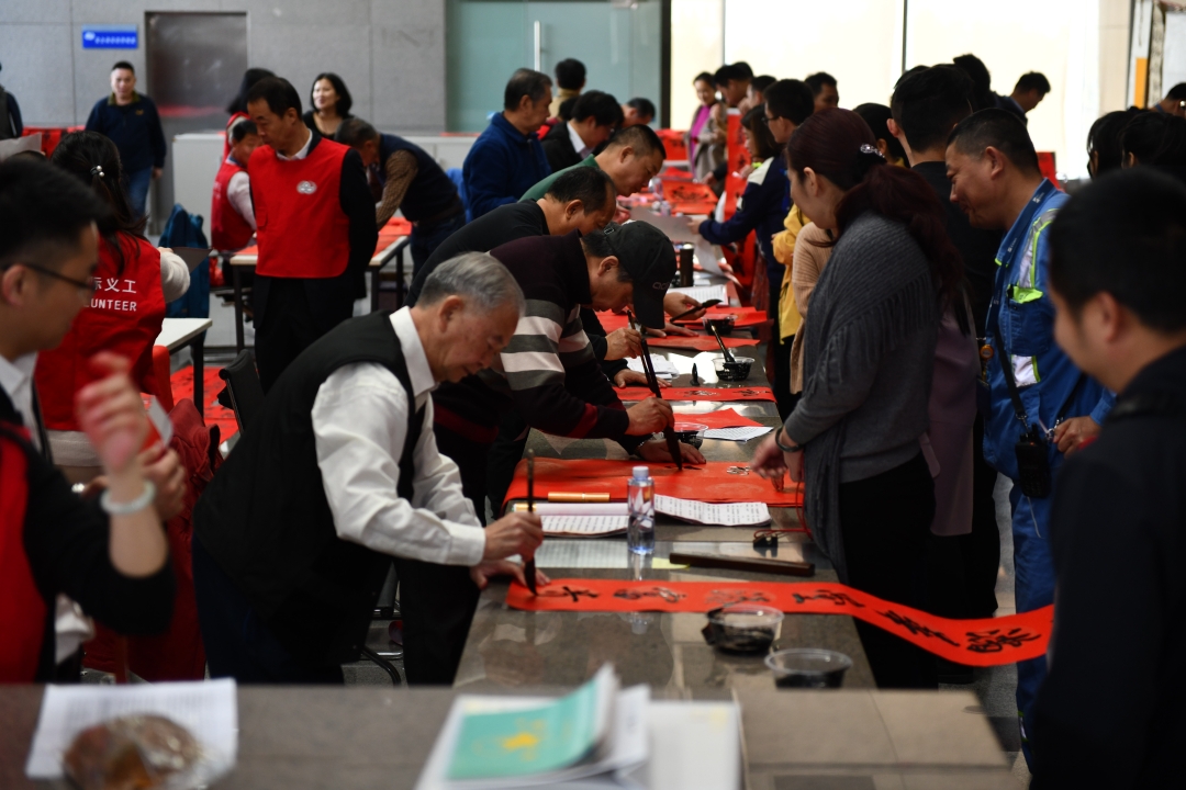 YICT volunteers write traditional New Year Couplets for staff members