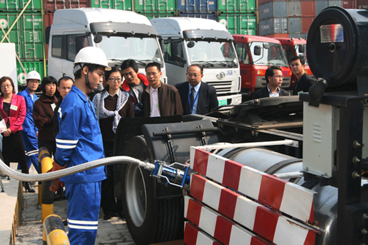 The worker demonstrates how to refuel a LNG container tractor